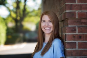 Julie smiles as she stands against a brick wall for the camera. She is a perfectionism therapist in Scotch Plains, NJ. Contact us today to learn more about therapy for perfectionism in Scotch Plains, NJ and other services. 07076