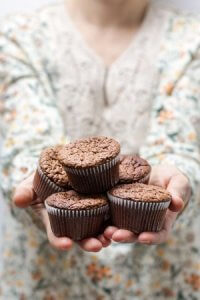 Little girl holding cupcakes