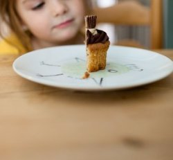 Little girl and half of a cupcake.