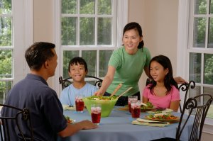 Photo of family eating at a table to represent how our therapists can help you cope with stress such as when your child has a food allergy.