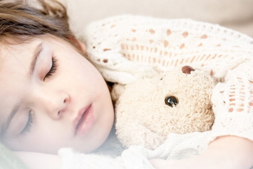 child sleeping with teddy bear