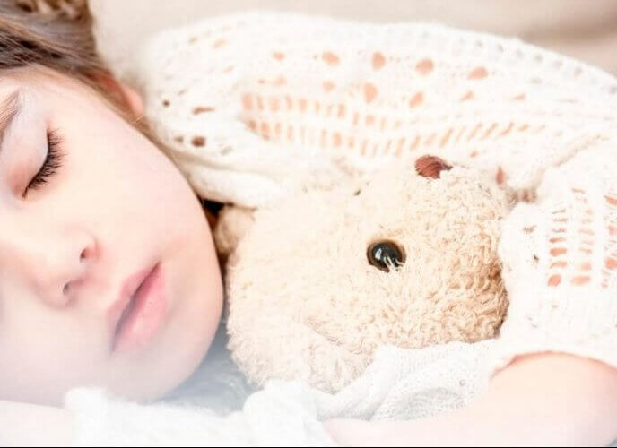 child sleeping with teddy bear