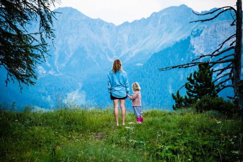 Mom and child standing among a mountain range