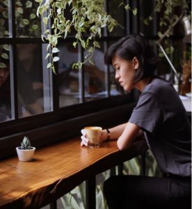 Mom sitting alone in coffee shop, stressed out.