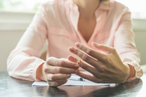 Woman removing her wedding ring signing divorce papers. Anxiety and rage in scotch plains, nj can cause problems with relationships. Anxiety treatment in Westfield, NJ can help. Or, with online therapy in New Jersey now!