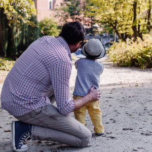 Father and son looking at something outside on the street, through the trees. The father feels more confident after working with a child psychologist in Scotch Plains, NJ for parenting advice and parent coaching. You can get parent counseling to compliment child therapy in union county nj or with online child therapy in New Jersey.