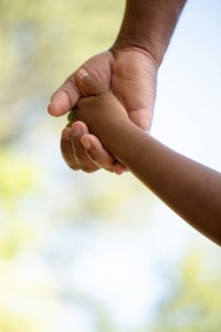 Adult holding hand of child after attending postpartum anxiety counseling in Scotch Plains, NJ at Brave Minds Psychological Services. Postpartum depression is available for Fanwood, Westflied, and Cranford residents.