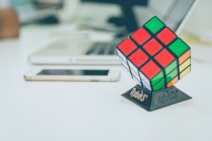 Rubix cube on a table next to a computer and phone. Children can get online therapy for kids in New Jersey with Brave Minds Psychological Services in scotch plains nj