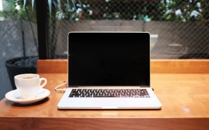 Laptop on desk with coffee ready for online therapy in New Jersey telehealth with a skilled online counselor from Brave Minds Psychological Services