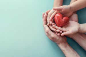 A group of hands holding a heart for family therapy, scotch plains, NJ. Families can get online counseling in New Jersey with Brave Minds online therapist in New Jersey.