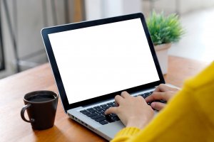 Woman typing on a laptop with a cup of coffee. Online Therapy in New Jersey is available for COVID 19 anxiety and stress to help with telehealth in New Jersey