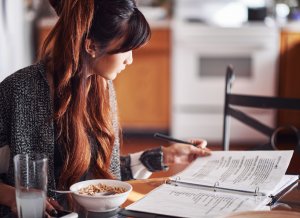 College student sits inside at the breakfast table. She looks over her notes while eating a bowl of cereal. They will have to use their laptop or tablet in order to make their classes. Brave Minds Psychological Services offers online therapy for college students in New Jersey. We also offer therapy for teens, and child therapy online in new jersey. Contact us today!