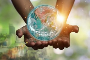 Hands holding blue earth globe over and blurred city background for World Environment Day. Parents and moms of newborns need support postpartum in a pandemic. You can get birth trauma therapy or postpartum depression counseling in Cranford, NJ. Scotch Plains and Westfield, New Jersey 07076