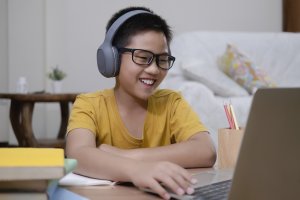 Cheerful boy excited using computer online learning schoolwork. Asian boy enjoy self study with e-learning at home. Online education and self study and homeschooling for virtual learning during COVID. You can get anxiety treatment in Westfield, NJ and Anxiety treatment in Cranford, NJ with Brave Minds in Scotch Plains, NJ