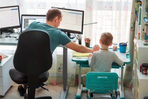 Father with kid trying to work from home during quarantine. Stay at home, work from home concept during coronavirus pandemic for virtual learning during COVID. You can get anxiety treatment in Westfield, NJ and Anxiety treatment in Cranford, NJ with Brave Minds in Scotch Plains, NJ