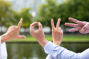 Romantic Couple Making Love Word With Hand Sign. Symbolizing the love languages for children and teens with anxiety for child therapy and teen therapy in Scotch Plains, NJ. You can get help with parent coaching and therapy for children with anxiety here and via online therapy in New Jersey