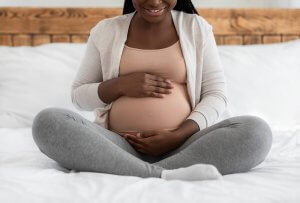 Third Trimester Of Pregnancy. Happy Black Expectant Woman Embracing her belly. Symbolizing the love languages for children and teens with anxiety for child therapy and teen therapy in Scotch Plains, NJ. You can get help with parent coaching and therapy for children with anxiety here and via online therapy in New Jersey