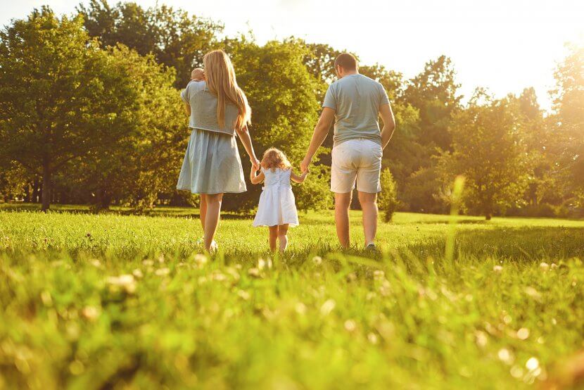 Happy family walking on the grass in the summer are doing well working with a child therapist for parent coaching for the love languages for children and teens with anxiety for child therapy and teen therapy in Scotch Plains, NJ. You can get help with parent coaching and therapy for children with anxiety here and via online therapy in New Jersey