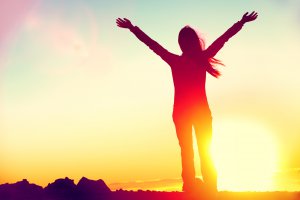 woman at sunset stands with arms raised above her head in celebration. This could symbolize the feelings of freedom experienced after overcoming trauma. We offer EMDR therapy in Scotch Plains, NJ, EMDR for children, and more. Contact an EMDR therapist for support today. 