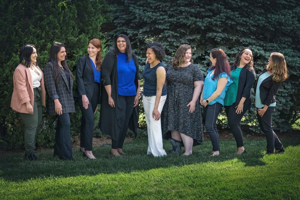 A group of therapists standing outside laughing with each other.