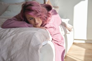 A teen smiles while writing in their notebook. Online therapy for teens can help even from the comfort of home. Learn more from a teen counselor in Scotch Plains, NJ.