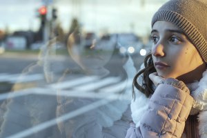 A child sits looking out a window with a blank expression. Anxiety counseling in Scotch Plains, NJ can offer support with child therapy for anxiety. Contact a child therapist today for more info about anxiety treatment.