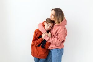A mother hugs her teen close. This represents the support anxiety counseling in Scotch Plains, NJ can provide with child therapy for anxiety. Contact us to learn more about anxiety treatment, or search "teenage anxiety therapist near me" today!