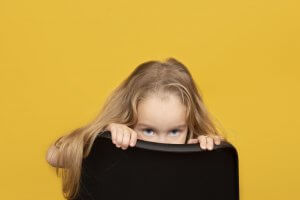 An image of a conspicuous child peering over a chair. | Child Counseling Scotch Plains, NJ, Parenting Help in Scotch Plains, NJ, Parenting Counseling in Scotch Plains, NJ | 07076