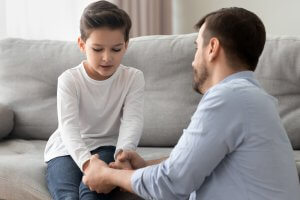 A father holds their child's hands as they listen to them. Anxiety counseling in Scotch Plains, NJ can offer similar support with child therapy for anxiety. Contact a child therapist for more info about anxiety treatment and other services.