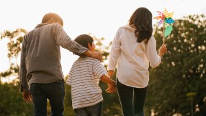 A family walk through the evening sun while holding hands, with mom holding a pinwheel. Parent counseling in Scotch Plains, NJ can offer support in combating rape culture. Learn more about sexual violence support in Scotch Plains, NJ today. Parenting help in Westfield, NJ can help you and your child today!
