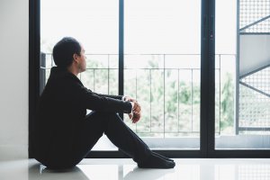 An Asian man sits on the floor as he looks outside. He appears lost in thought. Therapy for perfectionism in Scotch Plains, NJ can help you with perfectionism and overthinking. Contact a perfectionism therapist for support with anxiety counseling in Scotch Plains, NJ. 