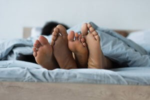 A close up of a couple's feet hanging out from under the covers. Parenting counseling in Scotch Plains, NJ can offer support with parenting help and sexual violence prevention in Scotch Plains, NJ! 07076