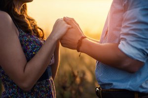 A couple hold hands as the sun sets behind them in the distance. Couples therapy in Scotch Plains, NJ can support you relationship and crate stronger bonds. Learn more about couples counseling today. 07076