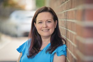 Elaine smiles while standing against a brick wall for a headshot. Learn how an EMDR therapist in Scotch Plains, NJ can offer support via EMDR for kids and other issues. Search for trauma therapy in Branchburg, NJ or “emdr for kids” today.