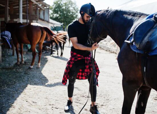 Image of a person about to ride a horse. This person could benefit from equestrian therapy in New Jersey. A trauma therapist in scotch plains, nj can help in equestrian related trauma therapy. (07076.)