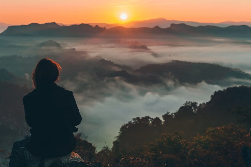 Woman sitting on an edge watching a sunset. We know that birth trauma therapy in Scotch Plains, NJ can help you recover from a traumatic birth. Start working with a trauma therapist today. | 07076