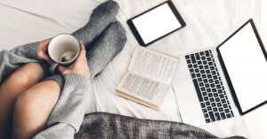 Image of person with computer and book with coffee. This person could be reading about antiracism in equestrian communities, or attending a session for equestrian therapy in New Jersey. A trauma therapist in Scotch Plains, NJ can help you with both. | 07076