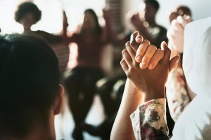 Diverse group holding hands at therapy to represent how online group therapy in new jersey can help you understand food allergies and anxiety. Contact us to start a support group near Westfield, NJ today!