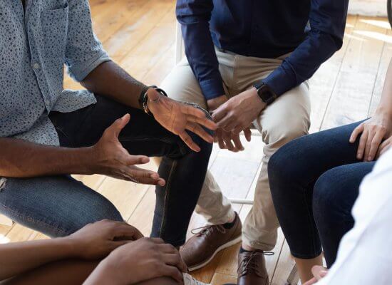 Group of people sitting in a tight circle to represent how group therapy can help teens with food allergies new jersey.