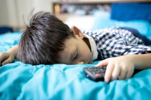 Sleeping child with remote in hand. Parent counseling in Scotch Plains, NJ can offer support in combating rape culture. Learn more about sexual violence support in Scotch Plains, NJ today. Parenting help in westfield, NJ can help you and your child today!