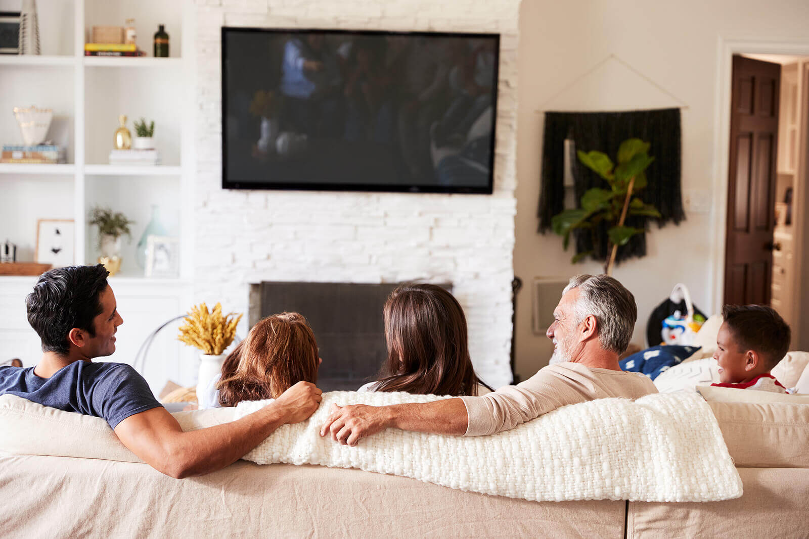 Image of a diverse family of 5 sitting on a couch laughing together. Don't let the narcissistic cycle continue. We can your whole family with trauma therapy and EMDR therapy for children in Scotch Plains, NJ 07016.