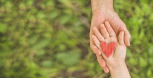 Image of a child and parents hand overlapping with a red heart in their palm. Teens with food allergies in New Jersey often also have anxiety. Dont let allergies and anxiety rule their life. Meet with a teen counselor Scotch Plains, NJ 07091.