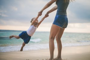 Image of a mother swinging her daughter by the arms on the beach. Anaphylactic reaction in New Jersey gives parents, kids, and teens. Get help with online therapy for teens and child therapy for anxiety in Scotch Plains, NJ 07033.