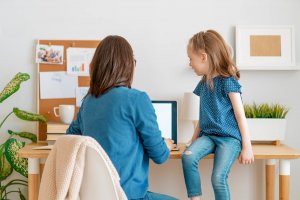 Image of a mom looking at a computer screen with her daughter. For parents food allergies and anxiety go hand in hand. An online therapist can help you address fears of anaphylactic reaction in New Jersey 07076.