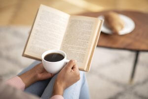 Image of a woman reading a book while drinking a cup of coffee. Did you suffer from narcissistic abuse in New Jersey? EMDR therapy and trauma therapy can help you recover. Start finding your true identity with a trauma therapist in Scotch Plains, NJ 07076.