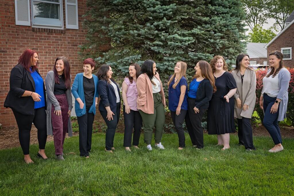 A group of therapists from Brave Minds. They are laughing together outside and having fun.