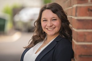 Headshot of Brianna Albanese as she poses in front of a brick wall. Learn more about the support a perfectionism therapist in Scotch Plains, NJ can offer support with addressing burnout and balance. Westfield NJ counseling can offer support via online therapy for college students in New Jersey today.