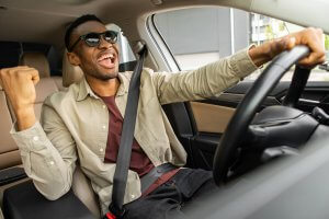 Joyful man driving a car safely and confidently. This picture represents the way anxiety treatment in Cranford, NJ, Westfield, NJ or Scotch Plains, NJ can help you thrive. Try online therapy in New Jersey here!