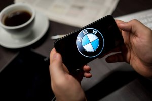 Person holding their phone with the BMW symbol on it with a desk in the background. Anxiety treatment in Scotch Plains, NJ can help with driving anxiety or fear of driving. Read tips from Westfield, NJ therapists here!