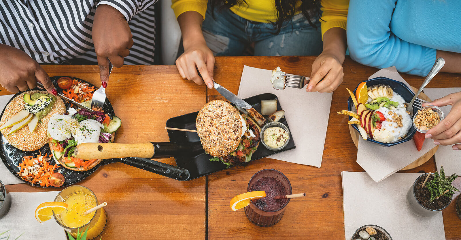 A top-down view of friends eating a variety of foods at a table. Learn how to overcome food allergies and anxiety by searching for anxiety treatment today. Search “signs of anxiety somerville, nj or westfield, nj” for support.